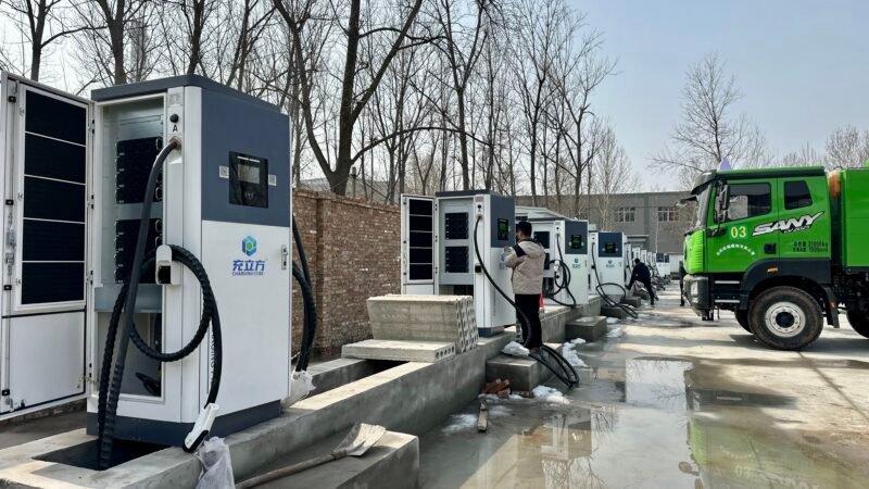 Technicians survey and commission the charging station.